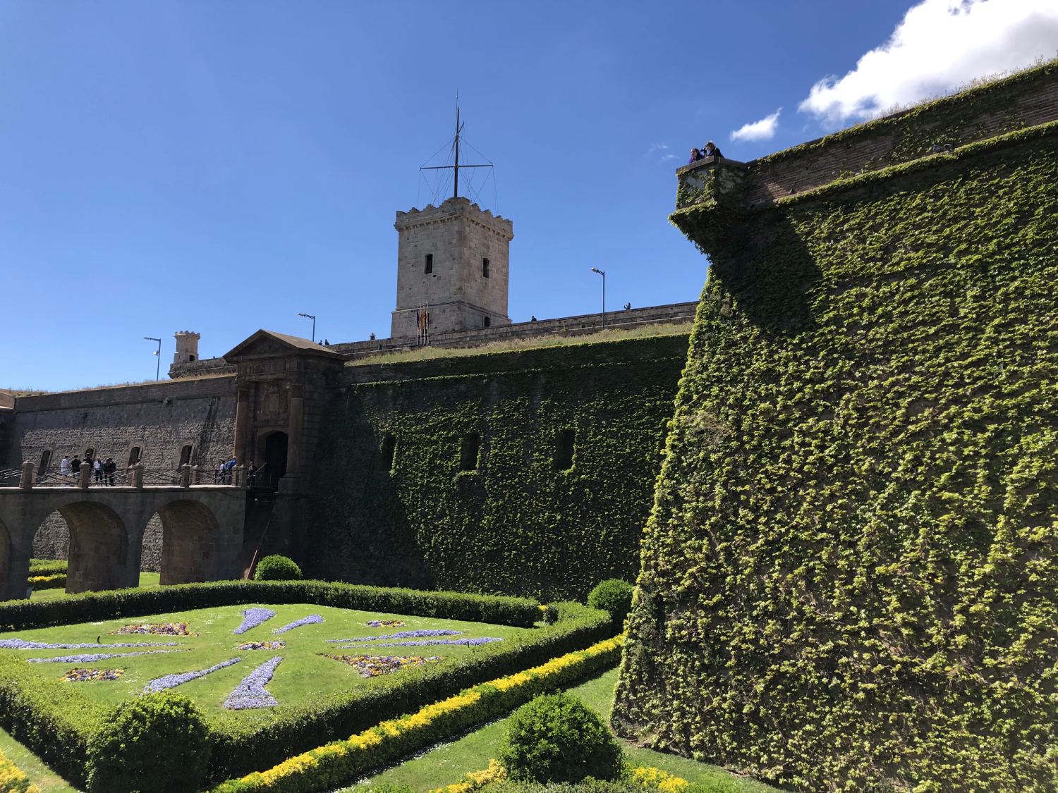 Montjuïc Castle walls and gardens beneath a blue Barcelona sky